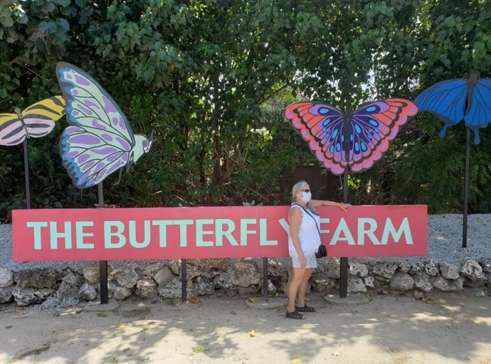 Tourguide na Butterfly Farm a bira malo debi na calor sofocante
