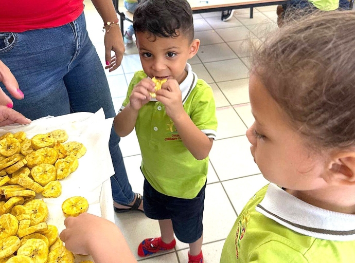 Muchanan di Colegio Conrado Coronel a disfruta di banana hasa cosecha di nan mesun hardin